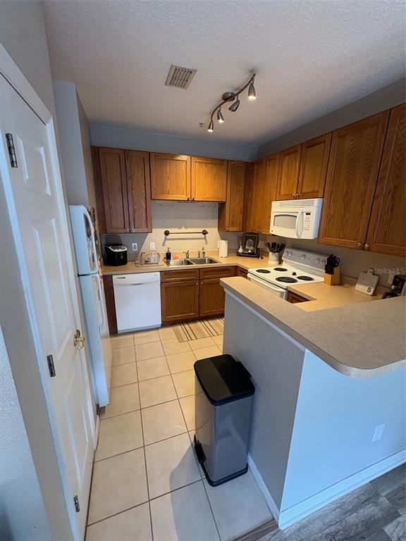 10106 Regent Square Drive, Unit 209 Orlando, FL 32825 - Photo 5 of 19 a kitchen with a stove a sink dishwasher and a refrigerator