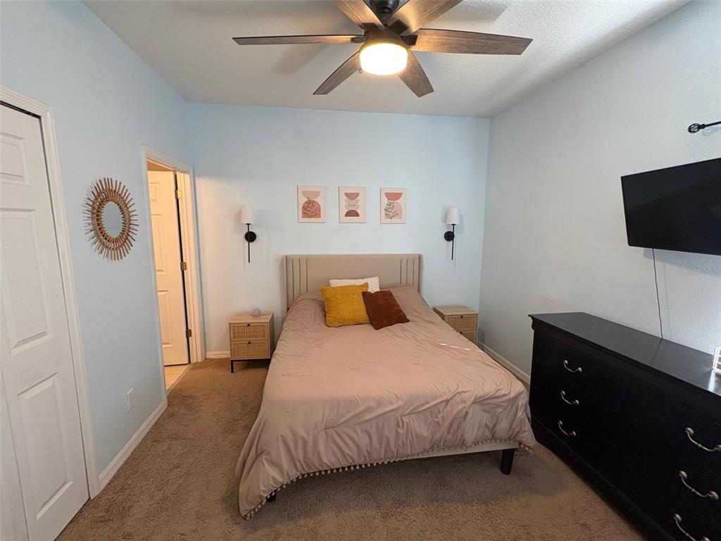 10106 Regent Square Drive, Unit 209 Orlando, FL 32825 - Photo 7 of 19 a bedroom with a bed and a flat tv screen on dresser