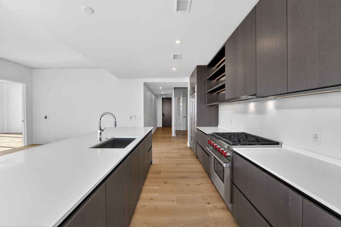 610 Davis Street, Unit 5001 Austin, TX 78701 - Photo 14 of 38 a kitchen with stainless steel appliances granite countertop a sink a stove and a refrigerator