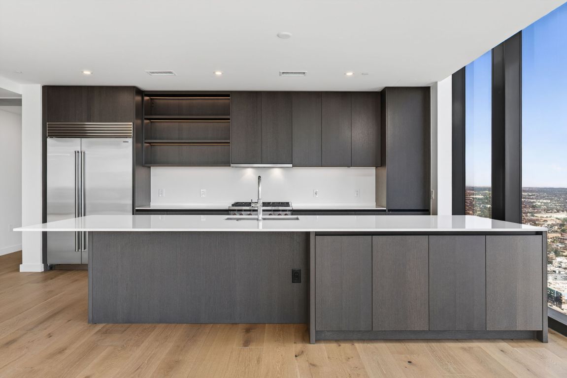 610 Davis Street, Unit 5001 Austin, TX 78701 - Photo 10 of 38 a kitchen with a sink and wooden cabinets