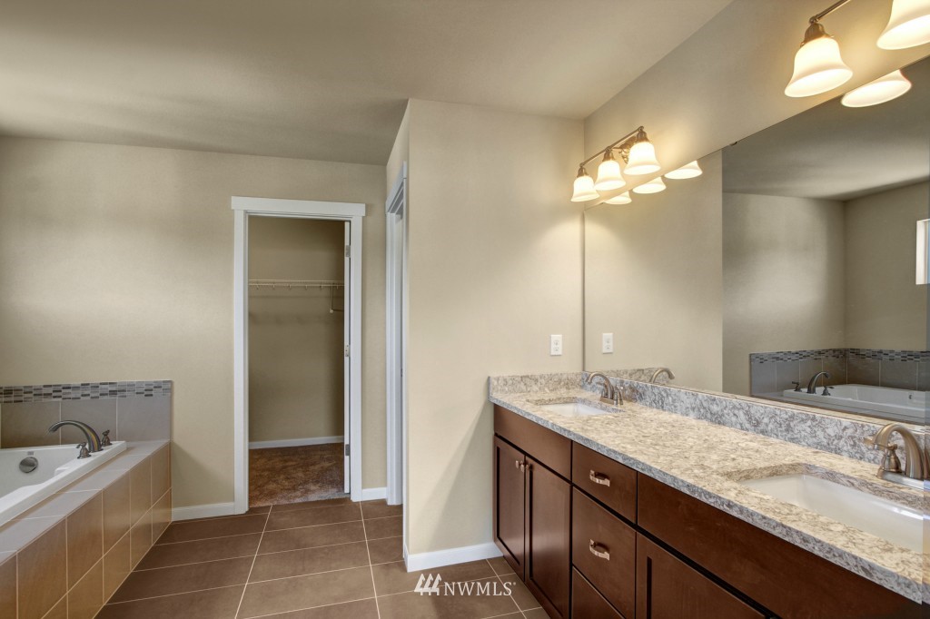 3526 178th Place Southeast, Unit 3012 Bothell, WA 98012 - Photo 12 of 20 a bathroom with a granite countertop sink a large mirror and a bathtub