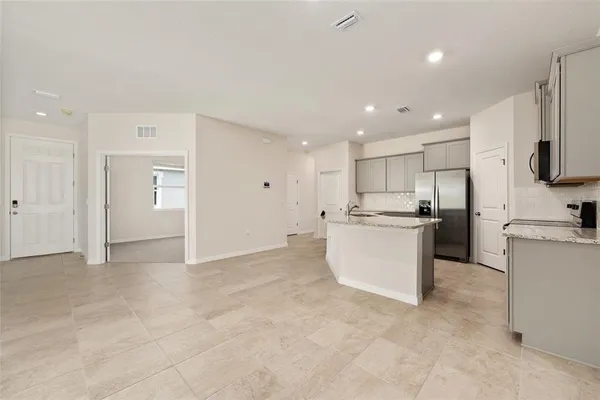 a kitchen with stainless steel appliances granite countertop a sink refrigerator and microwave