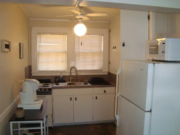 a kitchen with a sink a refrigerator and cabinets