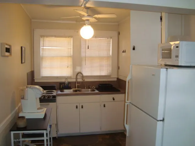 a kitchen with a sink a refrigerator and cabinets