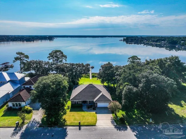 an aerial view of lake and residential houses with outdoor space
