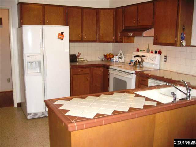 1965 Wren Street Reno, NV 89509 - Photo 4 of 9 a kitchen with a refrigerator sink and cabinets