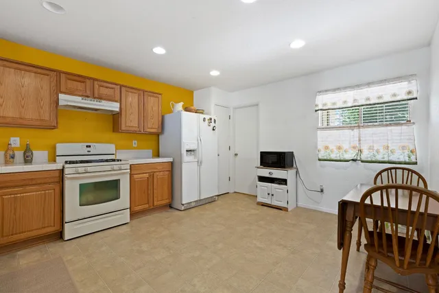 a kitchen with a refrigerator and a stove top oven