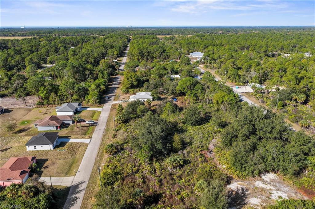3306 50th Street West Lehigh Acres, FL 33971 - Photo 12 of 16 an aerial view of residential houses with outdoor space and trees