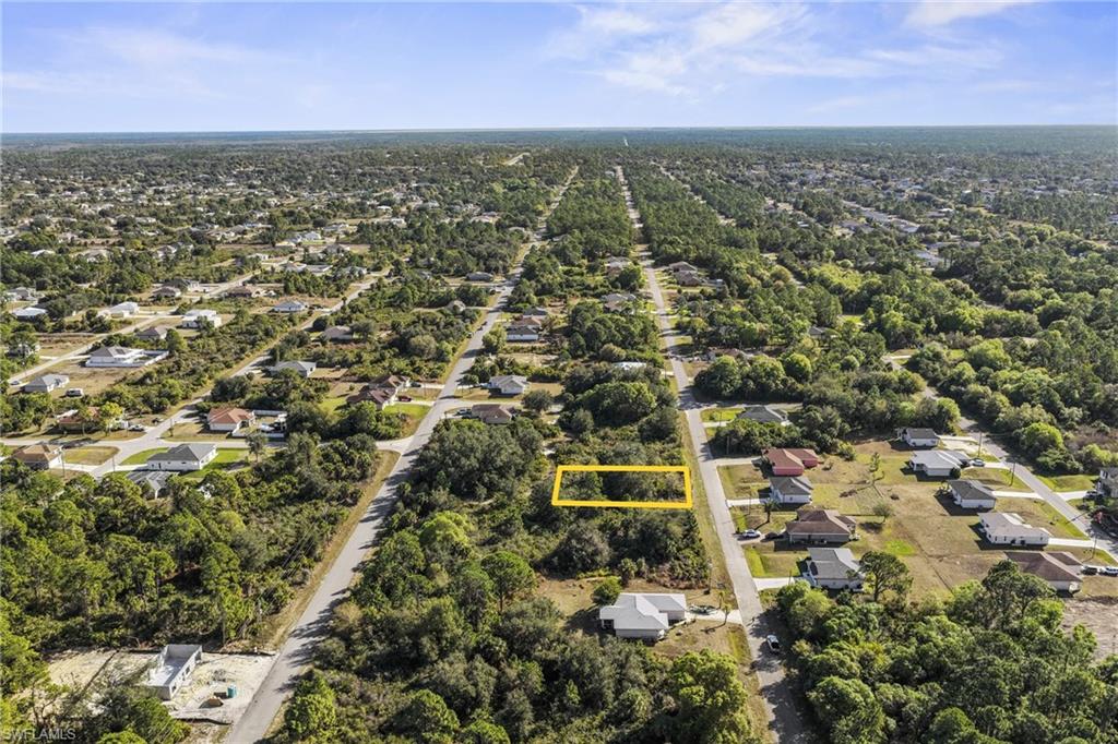 3306 50th Street West Lehigh Acres, FL 33971 - Photo 7 of 16 an aerial view of residential houses with outdoor space and trees