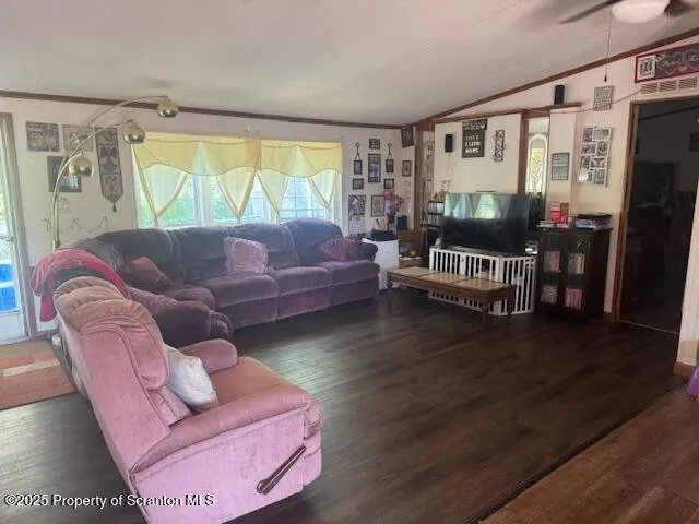 a kitchen with stainless steel appliances granite countertop a refrigerator a sink dishwasher a stove and a dining table with wooden floor