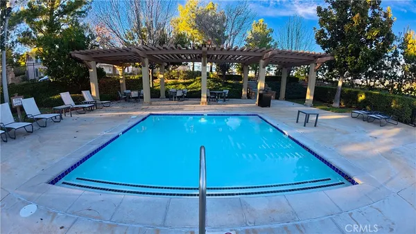 a view of a patio with a table and chairs under an umbrella