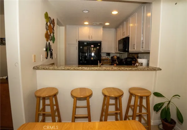 a kitchen with chairs and refrigerator
