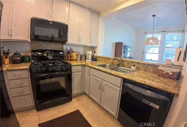 a kitchen with granite countertop a stove sink and microwave