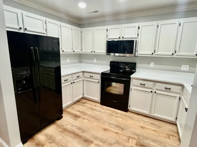 a kitchen with a refrigerator stove and white cabinets