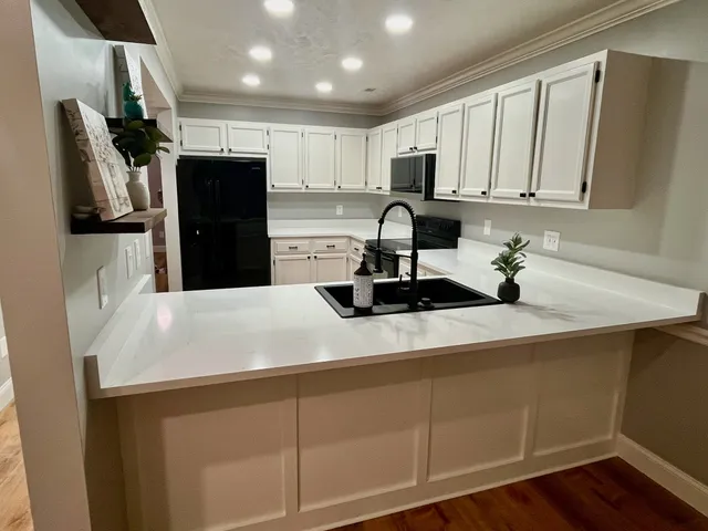 a kitchen with white cabinets and stainless steel appliances
