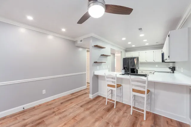 a kitchen with kitchen island appliances cabinets and wooden floor