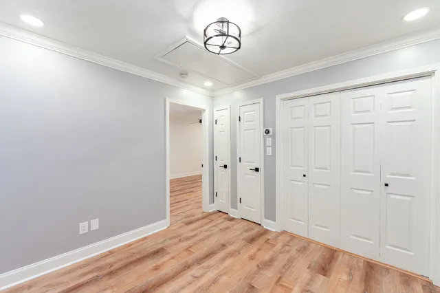 a view of a livingroom with a chandelier fan and wooden floor