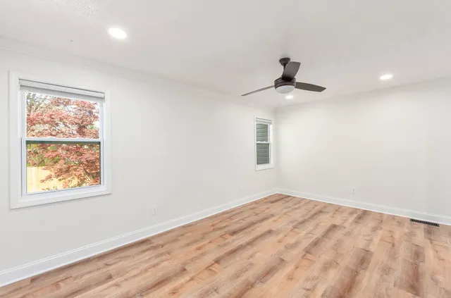 a view of a room with wooden floor and a ceiling fan