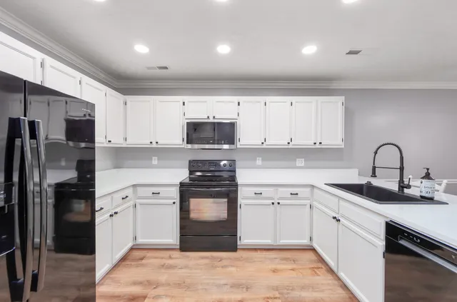a kitchen with white cabinets stainless steel appliances and sink