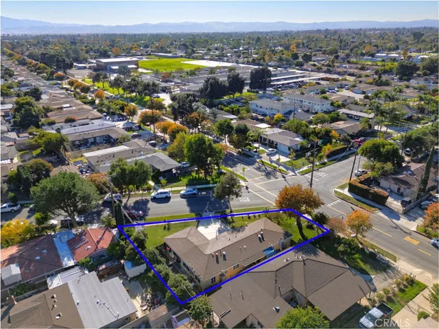 an aerial view of residential houses with outdoor space and parking
