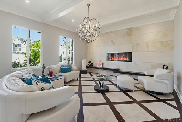 a living room with furniture a chandelier and a window