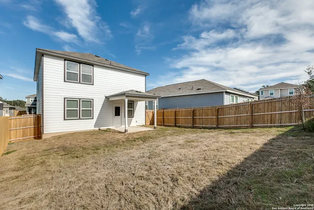a view of a house with a large window and wooden fence
