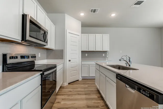 a kitchen with stainless steel appliances granite countertop a sink and a stove