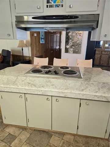 a large living room with stainless steel appliances kitchen island granite countertop a large window and a counter space