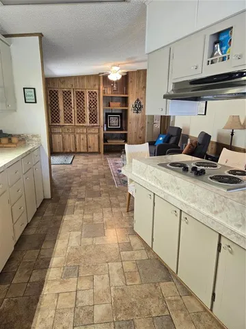a large kitchen with kitchen island granite countertop a large counter top cabinets and stainless steel appliances