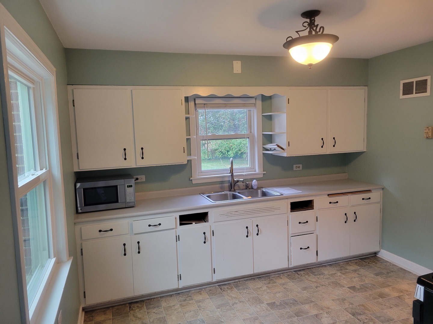 8918 Parkside Avenue Morton Grove, IL 60053 - Photo 13 of 36 a kitchen with granite countertop white cabinets white stainless steel appliances a sink and a window