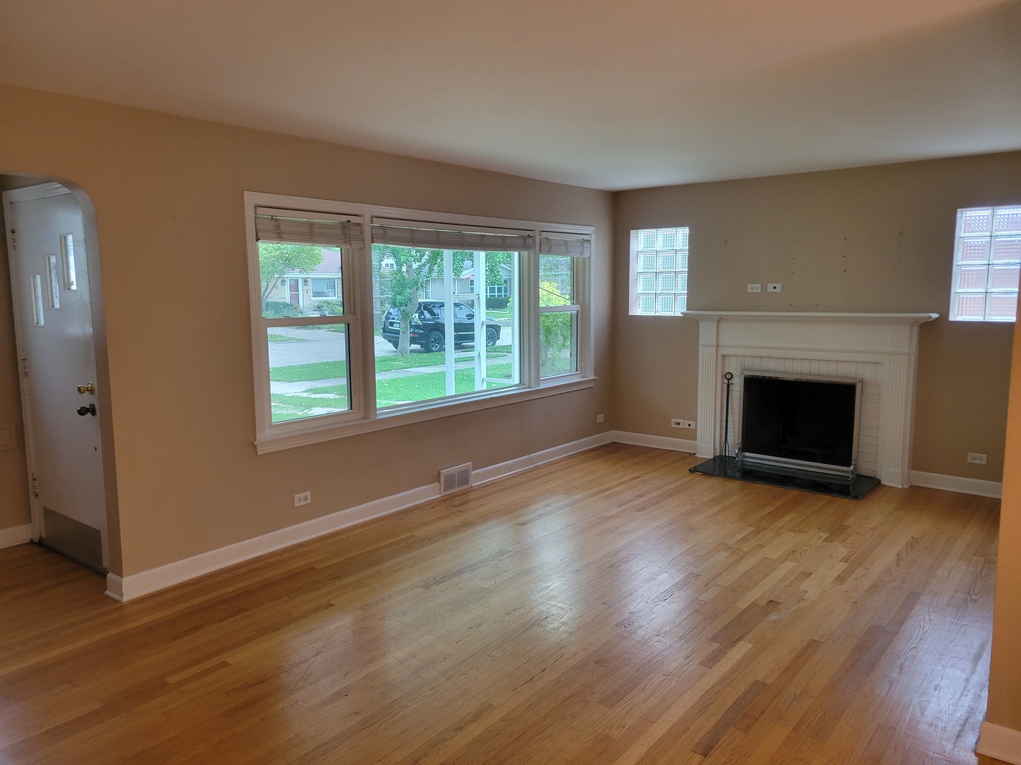 8918 Parkside Avenue Morton Grove, IL 60053 - Photo 19 of 36 an empty room with wooden floor fireplace and windows