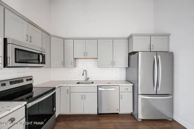 a kitchen with a sink appliances and cabinets