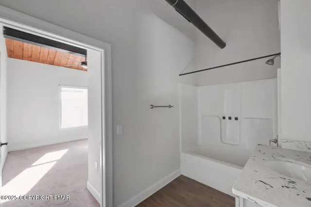 a bathroom with a granite countertop sink a toilet and shower