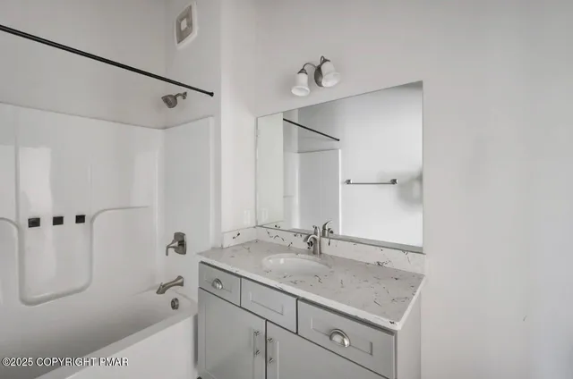 a bathroom with a shower sink and mirror