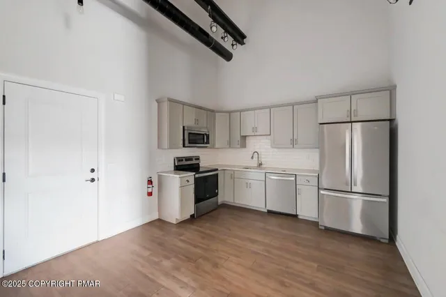 a kitchen with a refrigerator a stove top oven a sink and dishwasher