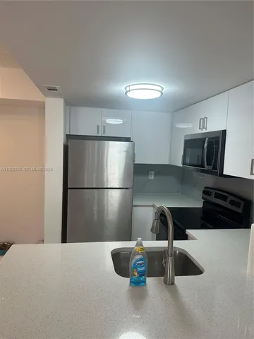 a kitchen with a refrigerator and a sink
