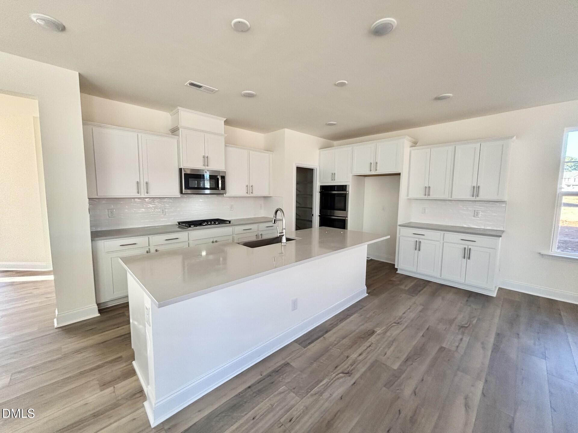 20 Gerrard Street, Unit 6 Franklinton, NC 27525 - Photo 9 of 31 a large kitchen with stainless steel appliances and white cabinets