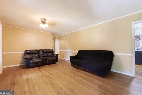 a living room with furniture and a wooden floor