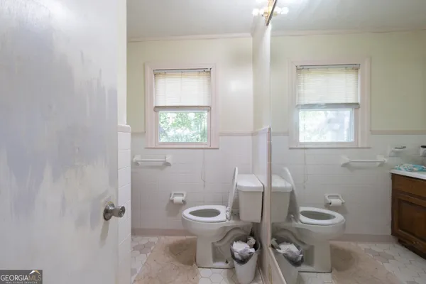 a bathroom with a toilet a sink and mirror