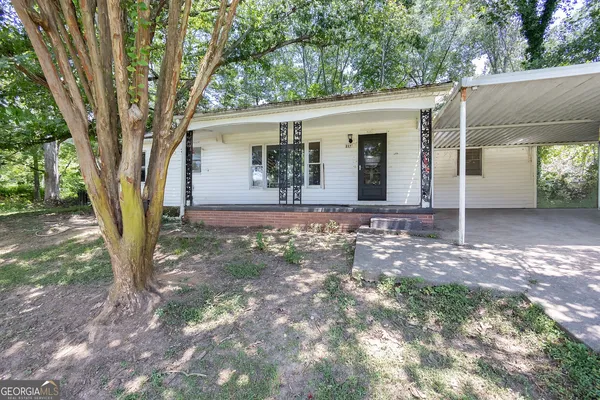 a view of a house with backyard and a tree