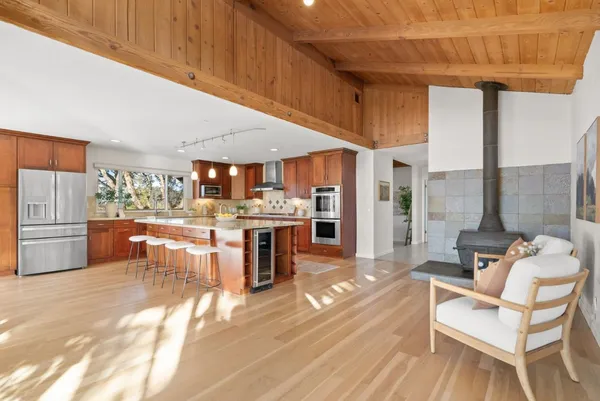 a room with stainless steel appliances kitchen island granite countertop furniture and a view of kitchen