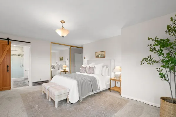 a bedroom with bed and a potted plant
