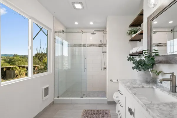 a bathroom with a granite countertop sink a mirror and a shower