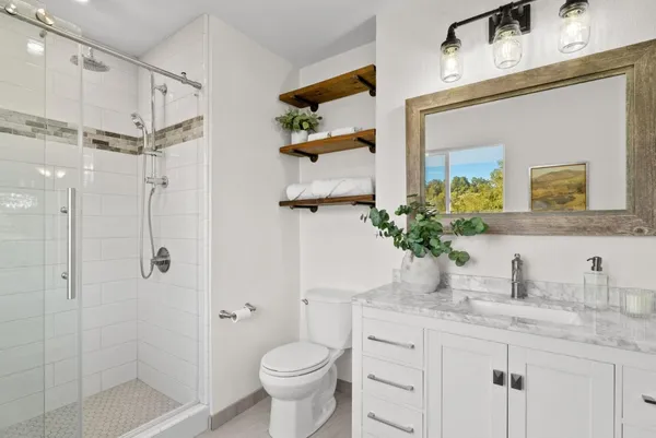 a bathroom with a granite countertop sink toilet and shower