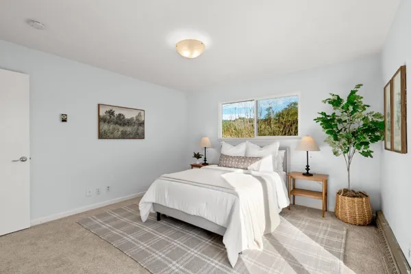 a bedroom with a bed and a potted plant