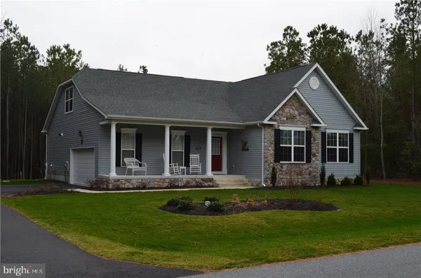 a front view of a house with a yard and trees
