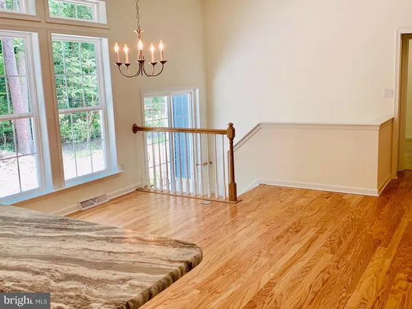 a kitchen with stainless steel appliances granite countertop a stove top oven a sink dishwasher and a refrigerator with wooden floor