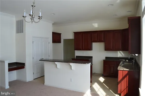 a kitchen with granite countertop wooden cabinets and a sink