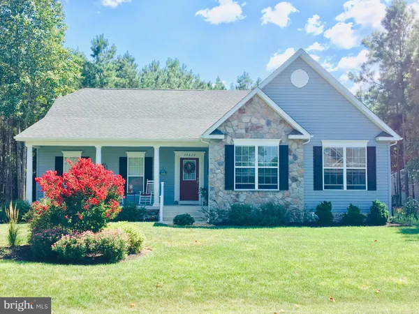 a front view of a house with a yard and outdoor seating