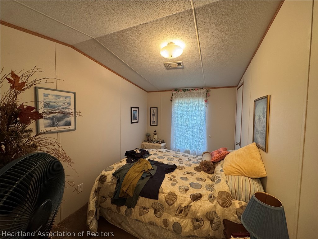 320 East 8th Street Frostproof, FL 33843 - Photo 13 of 17 a bedroom with a bed and a chandelier